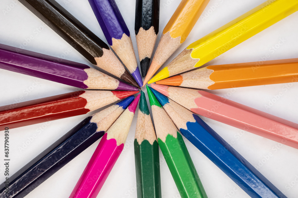 Color wheel of colored pencils on a white background, macro photo. Multi-colored pencils: yellow, orange, pink, purple. Drawing, art, wallpaper, mockup background, layer for the site