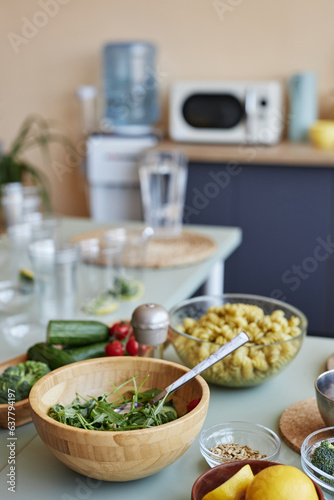 Vertical background image of kitchen setting with healthy food and ingredients on kitchen counter, copy space