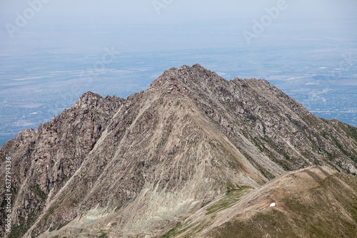 Obraz na płótnie The majestic Big Almaty Peak rises above the vast metropolis w salonie