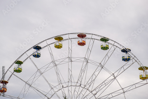 Big Ferris wheel against the sky on a cloudy day. Cabins in different colors. Place of entertainment and recreation.ferris wheel against a blue sky. High quality photo