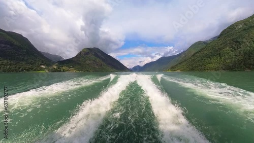 Waves and wake behind fast moving boat in Fjaerlandsfjorden glacier green sea Norway - Summer wide angle sightseeing boat clip photo