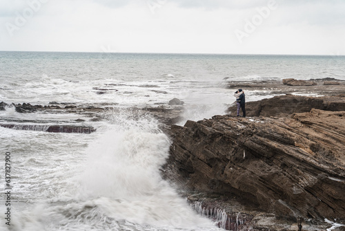 Couple in love embrace in stormy weather by the sea