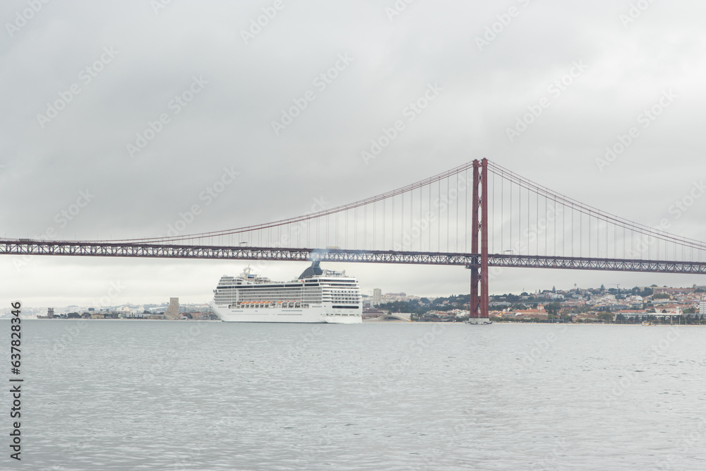 Huge cruise ship passes along the river under the bridge in cloudy weather