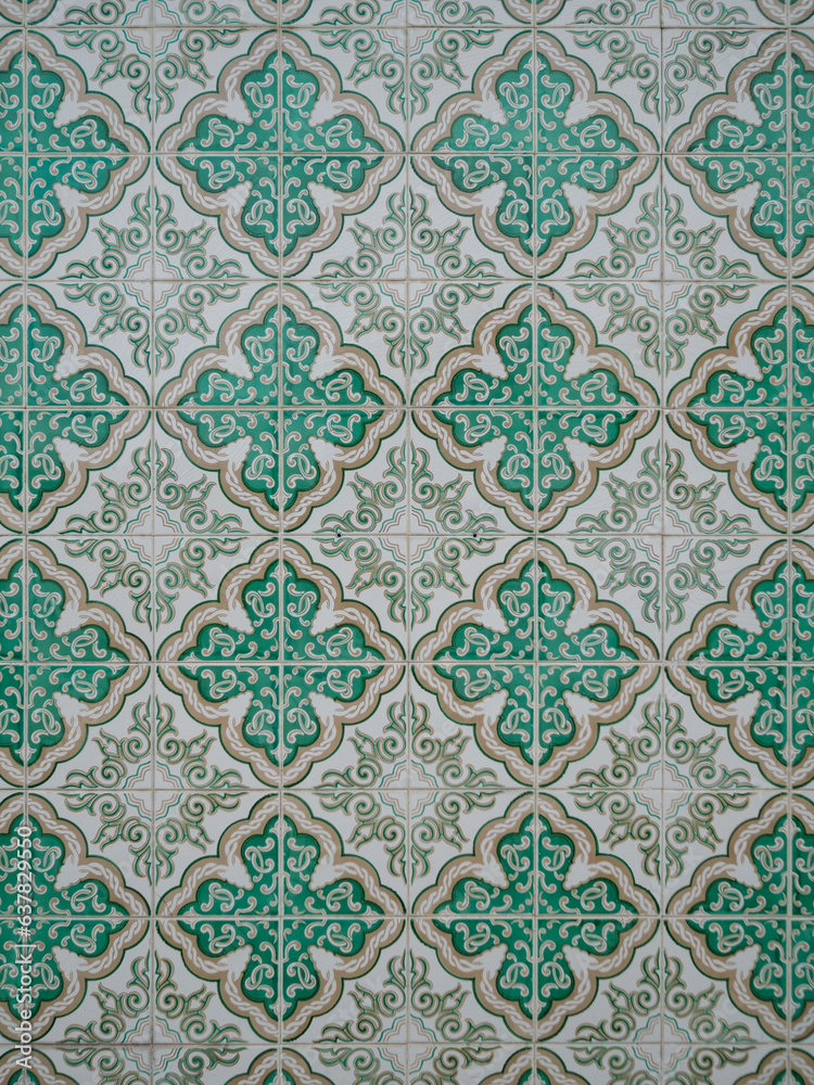 close-up of a wall tiled with green, white and handmade tiles in portugal