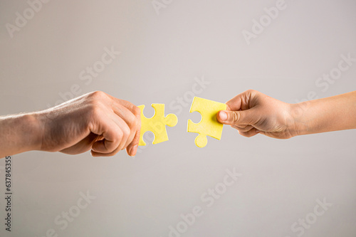 Mens and childs hands connecting puzzles. Hands connecting puzzle. Puzzles. Hand of the child and hand of mother fold puzzle, closeup. Hands hold puzzles. Solution of problems