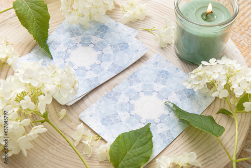 Deck with homemade divination Angel cards on wood table with hydrangea flower for decoration. Home indoors candle burning. photo