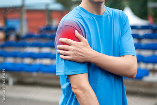 Diseases of the shoulder joint, bone fracture and inflammation, athletic man on a sports ground after workout suffering from pain in hand