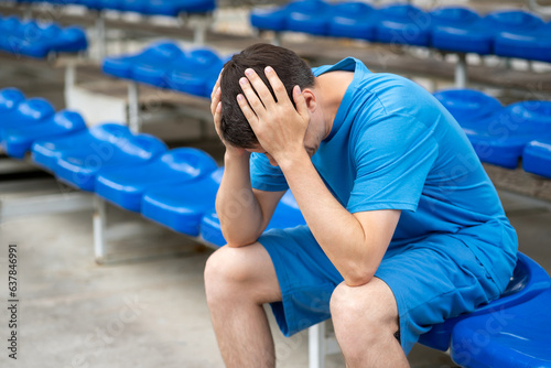Headache and migraine, man with head pain after workout on a sports ground photo