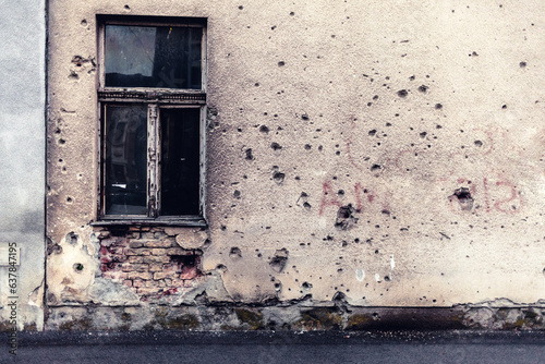 Damaged building in Ukraine war. Historic war damage, bullet holes in residential building. photo