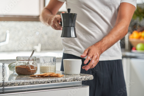 Fototapeta Naklejka Na Ścianę i Meble -  Unrecognizable man pouring hot coffee from moka pot
