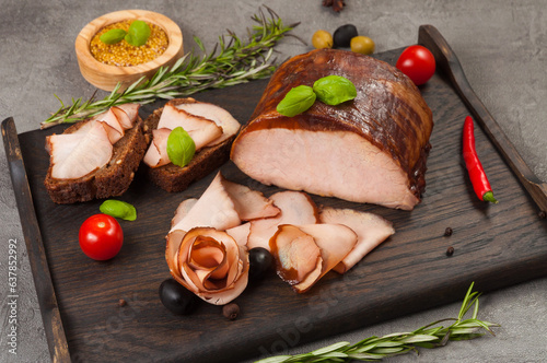 boiled and smoked pork delicacies on a dark wooden board