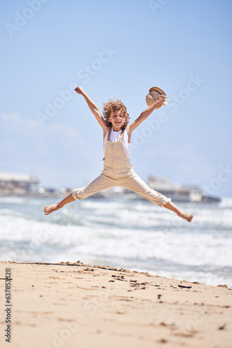 Carefree boy jumping on sandy beach