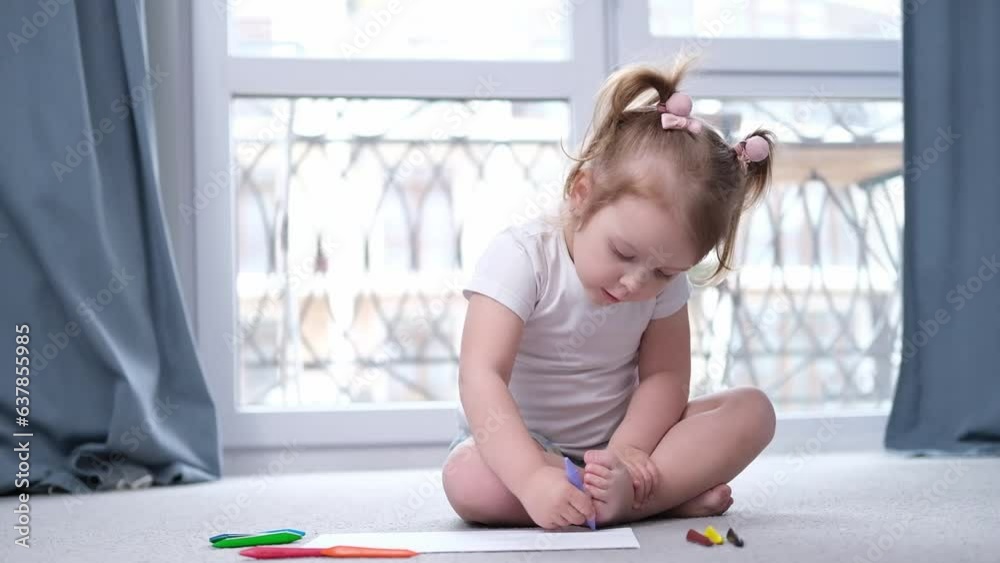 Cute pretty small kid girl artist playing alone drawing picture with pencil sit on floor, focused smart preschool child enjoying creative art activity at home, children development concept Cute pretty small kid girl artist playing alone drawing picture with pencil sit on floor, focused smart preschool child enjoying creative art activity at home, children development concept