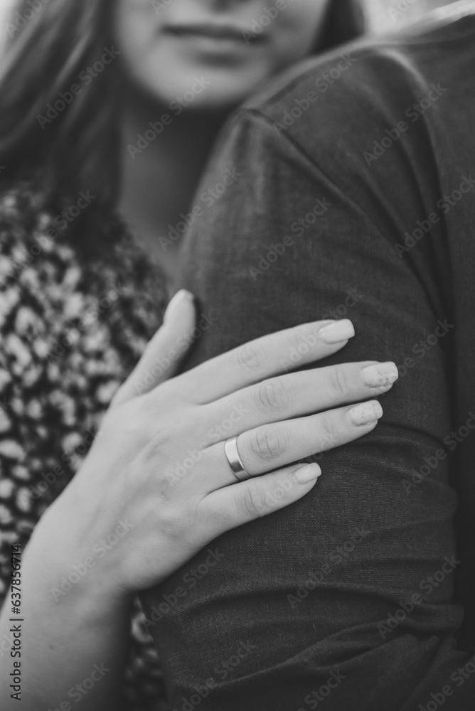 Engagement ring. Woman hug man. Photo married couple hugging, husband and wife. Closeup. Summer. Portrait of romantic male and female in love on nature. Husband and wife embrace. Black and white photo