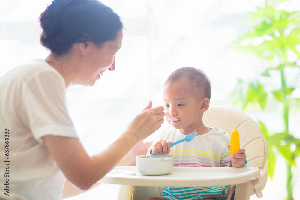 Obraz premium Baby eating solid foods in high chair.