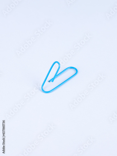 Blue paperclip isolated on white background.