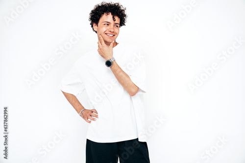 Portrait of young attractive man with curly hair hairstyle. Smiling handsome male in casual stylish white t-shirt clothes posing in studio. Cheerful and happy model isolated on white