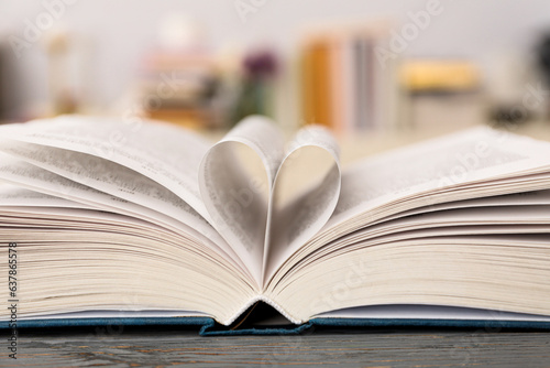 Heart from book pages on light background