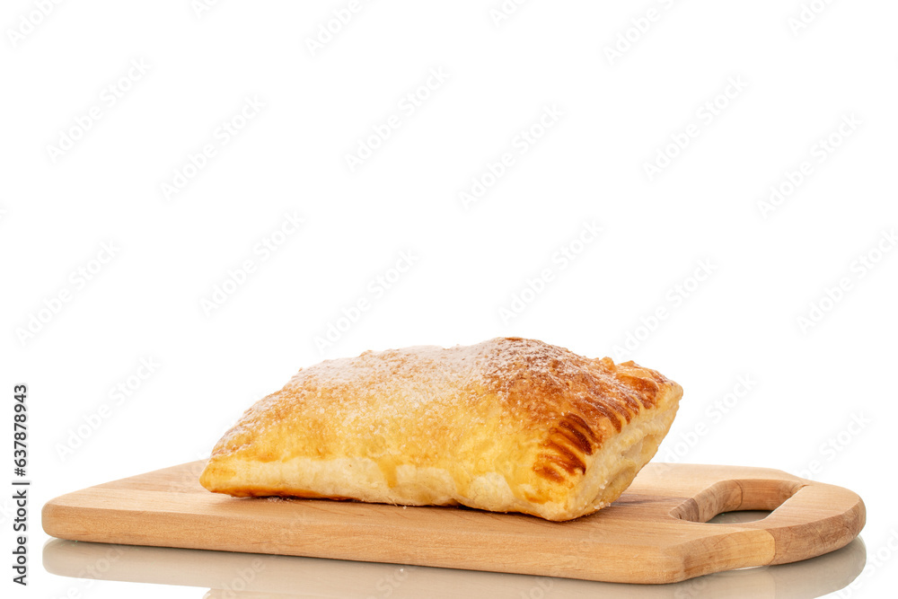 One aromatic puff pastry bun with apples on a wooden kitchen board, macro, isolated on white background.