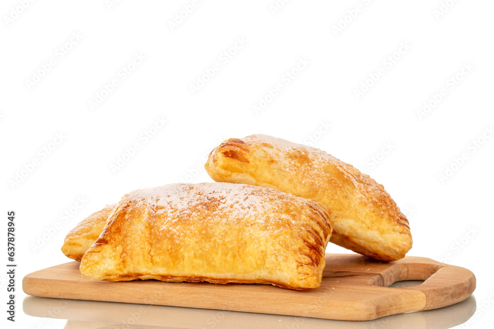 Two aromatic puff pastry buns with apples on a wooden kitchen board, close-up, isolated on white background.