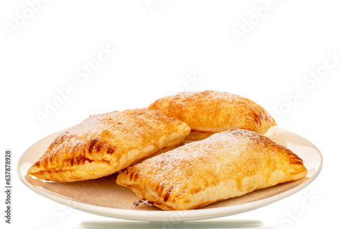 Three fragrant puff pastry buns with apples on a white ceramic plate, close-up, isolated on a white background.
