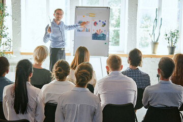 Audience listening to instructor in employee education training session. Office worker community summit forum with expert speaker.