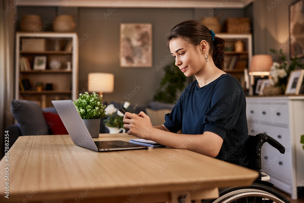A female freelancer in a wheelchair texting messages on a phone while working on a laptop. A female freelancer in a wheelchair texting messages on a phone while working on a laptop.