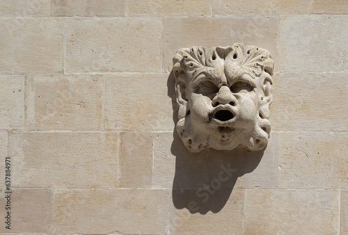 The face protrudes from the white stone wall. Background with copy space. Dubrovnik Croatia. Selective focus