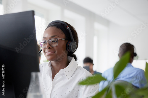 Mid adult woman using headset while sitting in office photo