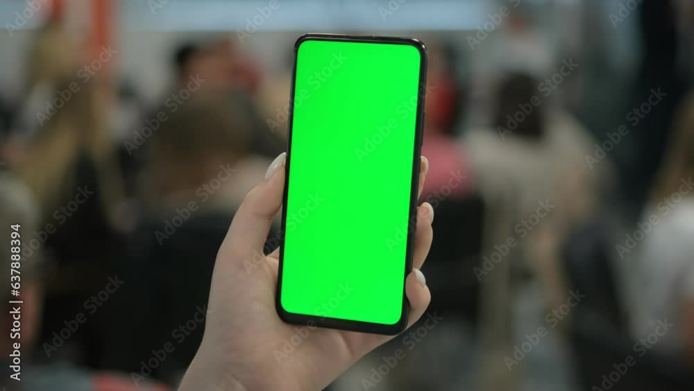 A woman with a smartphone in her hand. Point of View of Woman at Phone with Green Screen for Copy Space. The concept of a successful business woman, feminism. Close-up. A woman with a smartphone in her hand. Point of View of Woman at Phone with Green Screen for Copy Space. The concept of a successful business woman, feminism. Close-up.