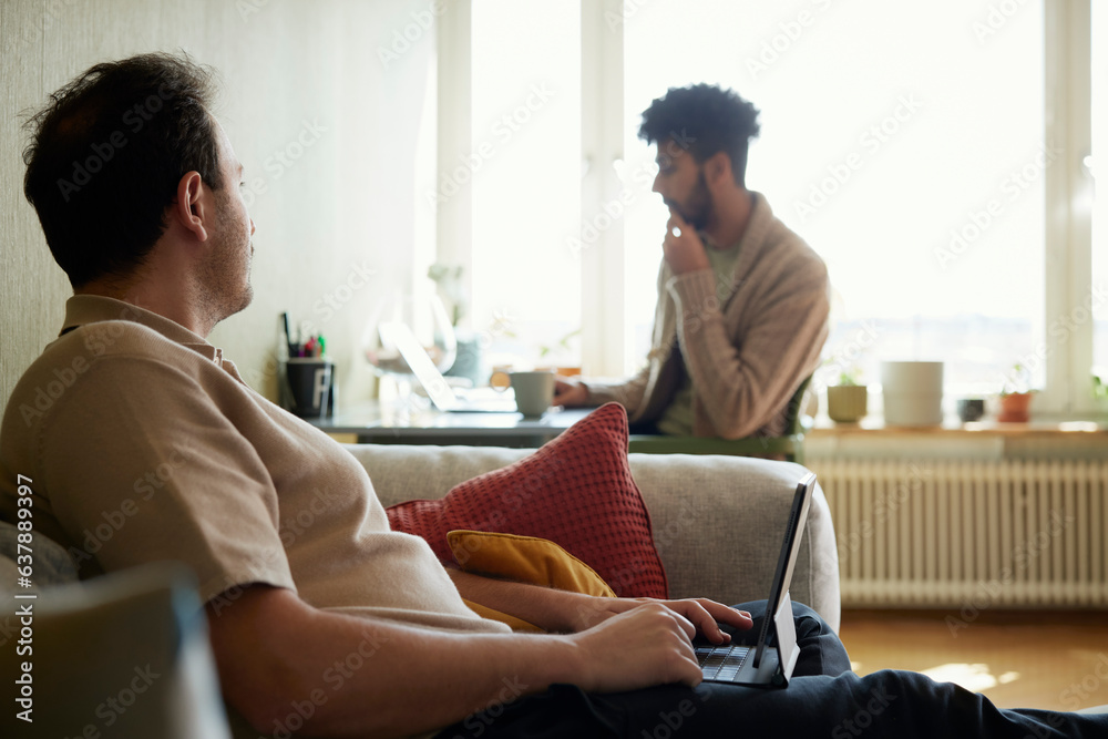 Homosexual couple relaxing in living room Homosexual couple relaxing in living room