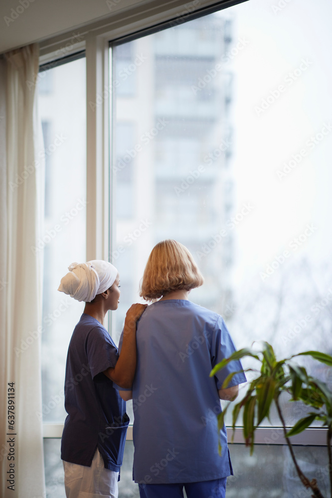 Female doctors standing and talking at hospital corridor Female doctors standing and talking at hospital corridor