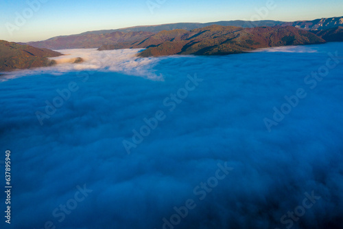 Aerial view of morning fog in the valley in dawn © salajean