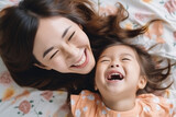 Top view of a mother and her daughter laughing cheerfully