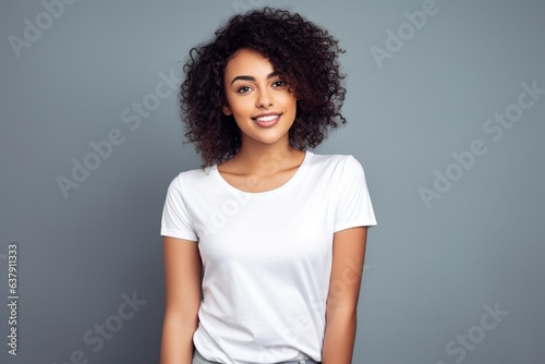 attractive smiling female with brown hair wearing white tshirt for mock up on plain grey background