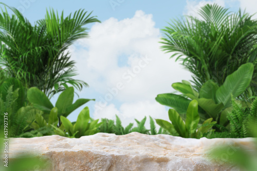 Stone podium table top outdoors tropical forest plant blur cloud blue sky nature background.Healthy product present natural placement pedestal stand display,spring and summer paradise jungle concept.