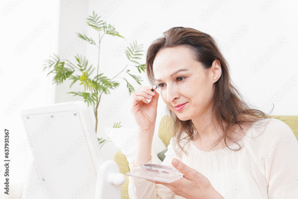 自宅で化粧をする若い女性 自宅で化粧をする若い女性
