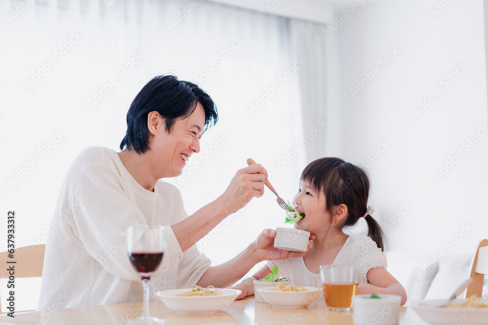 パパと一緒にご飯を食べる小さな女の子 パパと一緒にご飯を食べる小さな女の子