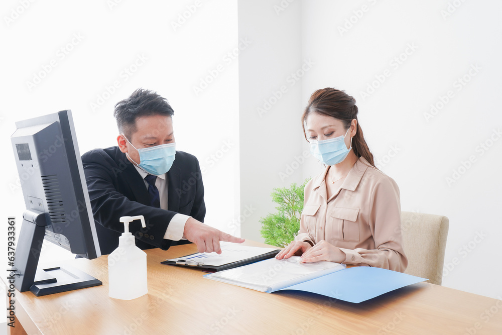 感染症対策をしてオフィスで働くビジネスパーソン 感染症対策をしてオフィスで働くビジネスパーソン