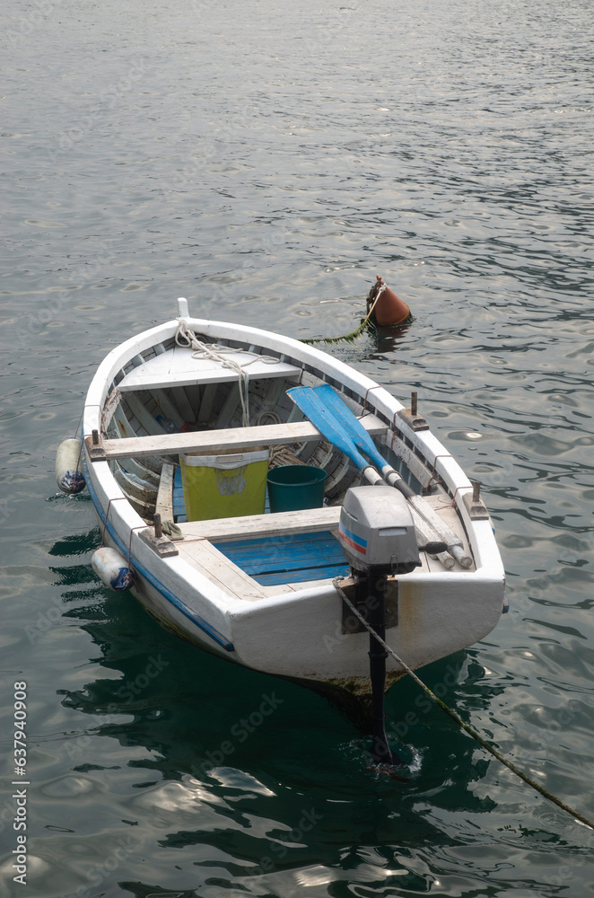 Obraz premium Small wooden boat with motor tied to a buoy in water in Montenegro, Europe