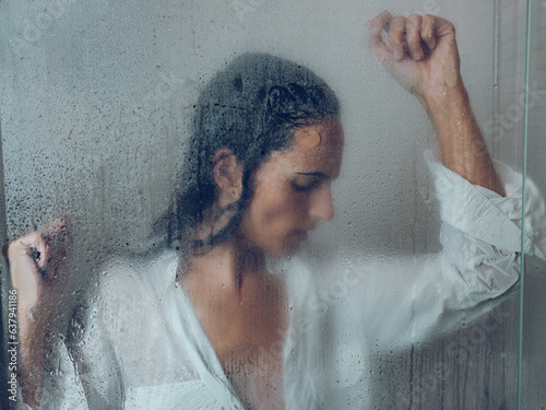Upset woman in wet shower cabin