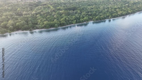 Morning light illuminates a forest-covered island found just off the north coast of Sumbawa in Indonesia. This volcanic region, in the ring of fire, harbors high marine biodiversity. photo