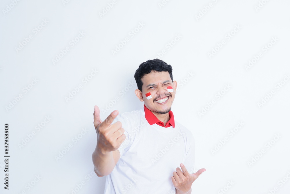 Indonesian man showing excitement with thumbs up when celebrating Indonesia independence day Indonesian man showing excitement with thumbs up when celebrating Indonesia independence day