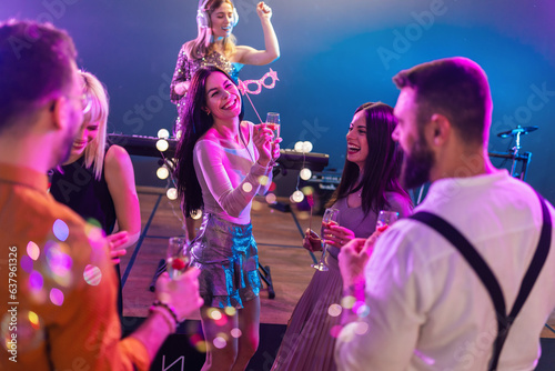Group of young beautiful people partying at the club. Celebrating and drinking alcohol