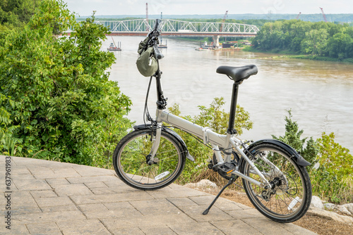 lightweight folding bike on a high shore of the Missouri River above Katy Trail overseeing bridge construction near Rocheport, MO in summer scenery photo