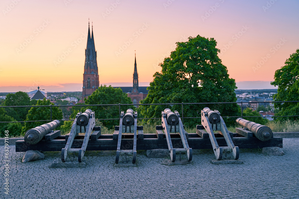 Uppsala, Sweden. Old Cannons in front of the Castle with Uppsala Cathedral on background at dusk