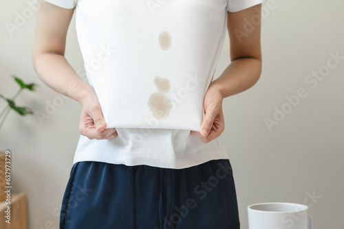 Fotografie Clothes stain dirty from food concept, people get a coffee drop split from glass on the t-shirt