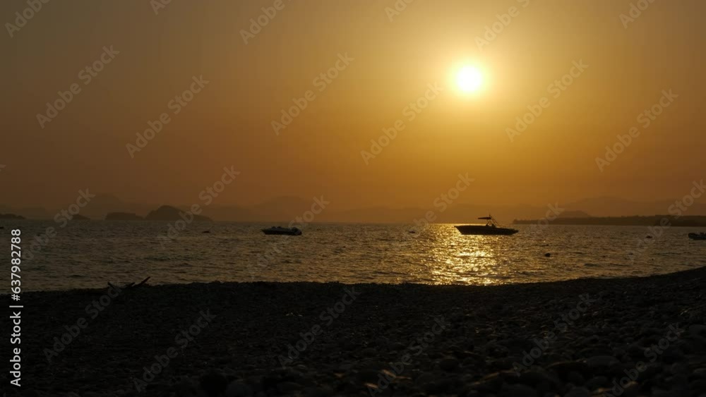 Silhouette motorboat during dusk. A nice orange dusk with two motor boats silhouette in the sea during vacation time. Silhouette motorboat during dusk. A nice orange dusk with two motor boats silhouette in the sea during vacation time.