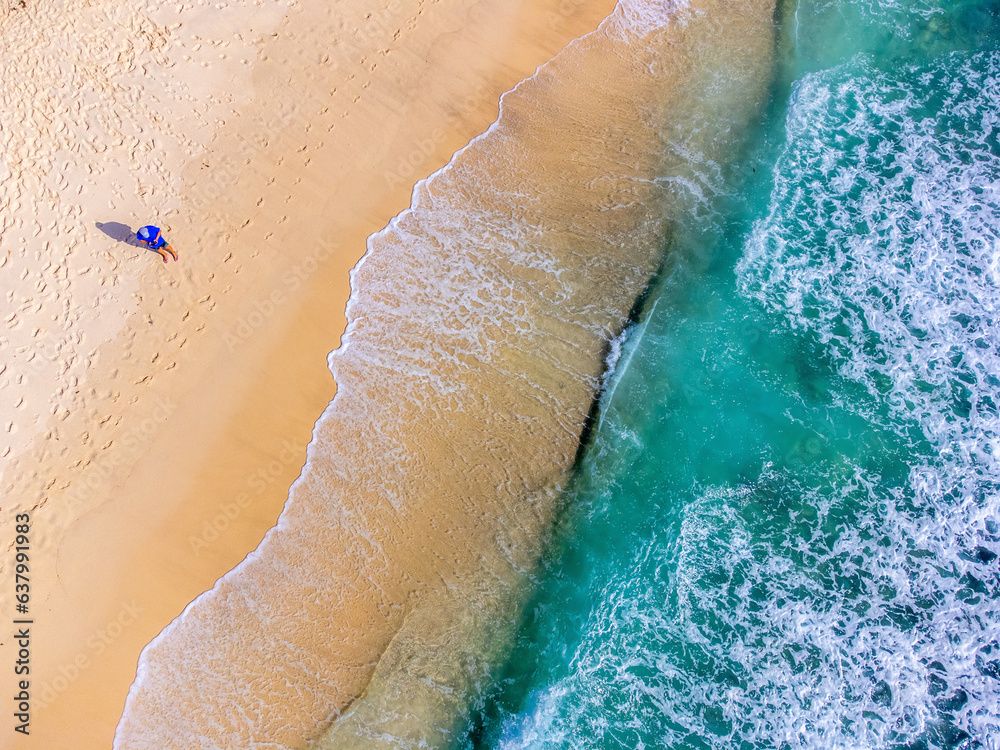 Aerial view of a man by the sea in Takamaka beach