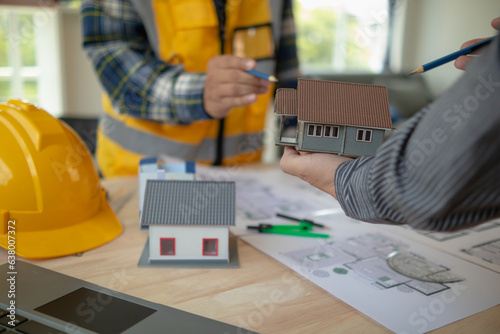 Construction engineers discuss and exchange ideas with architects to improve house plans to meet customer needs. A concept for exchange of design ideas between construction engineers and architects.